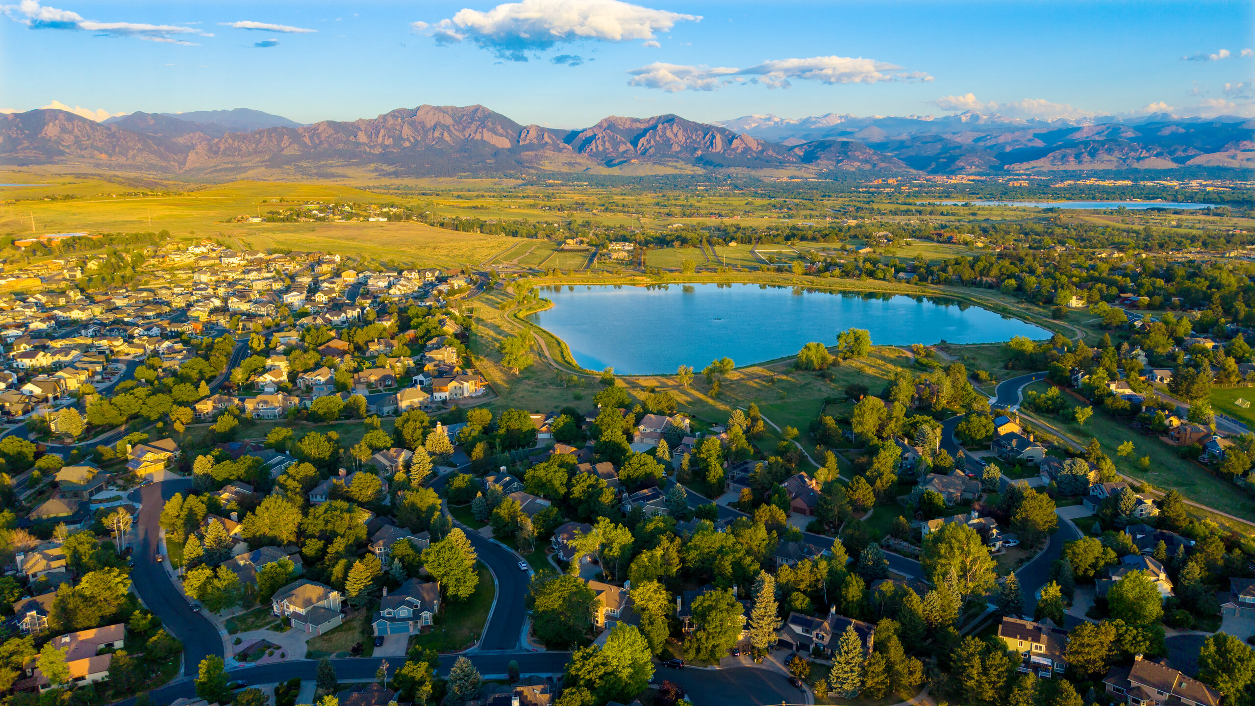 Real aerial photo of the Waneka Lake neighborhood with the Flatirons in the background, shot by Foothills Film + Footage