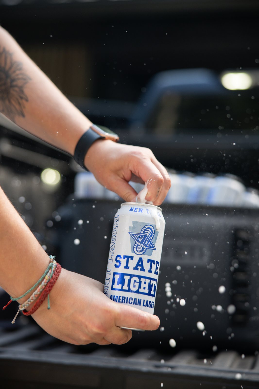 Hand pulling a State Light can from ice in a truck bed