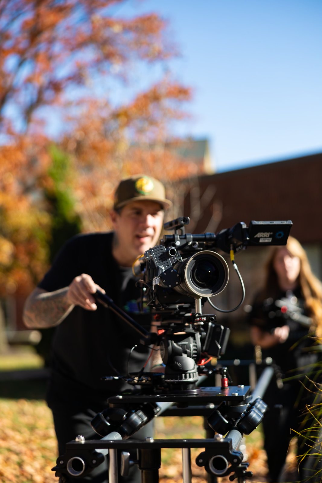 Camera operator with the ARRI rig outside under fall trees