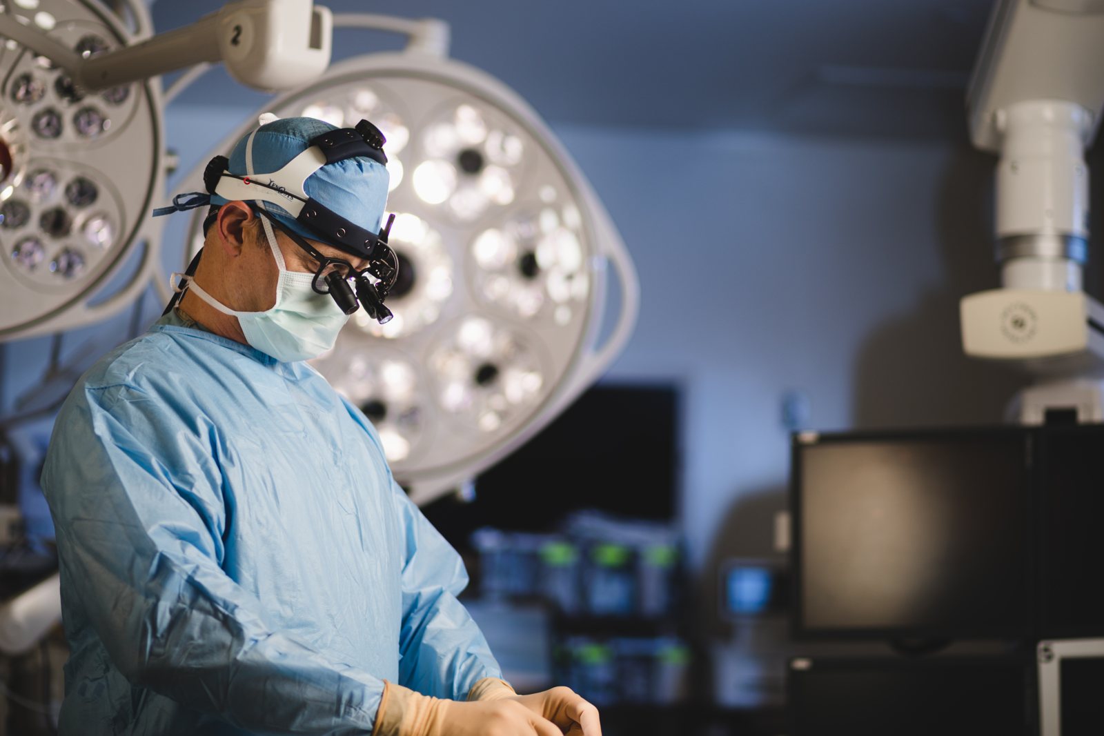 Surgeon with loupes working under operating room lights