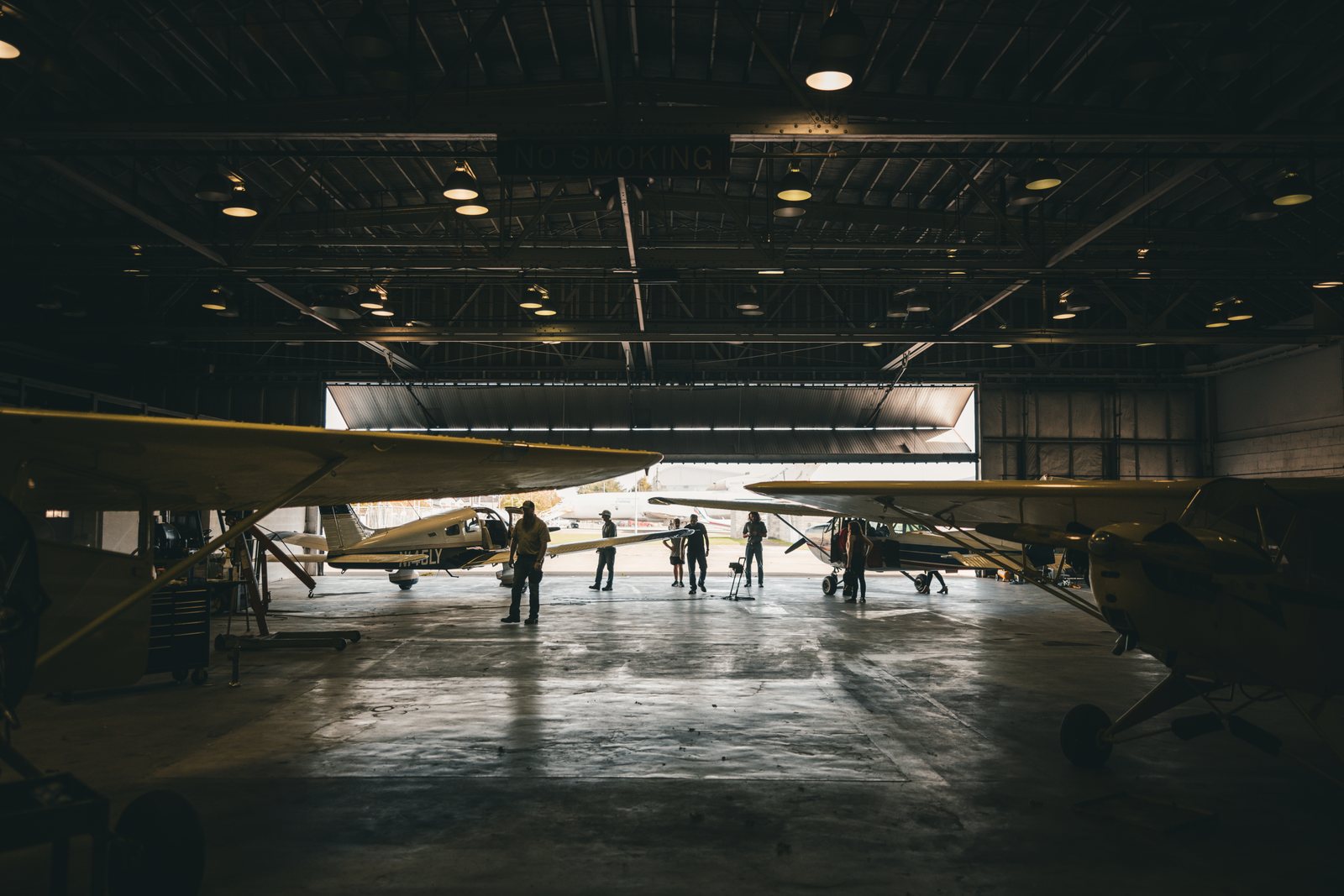 DMK crew filming inside a Lycoming hangar lined with aircraft