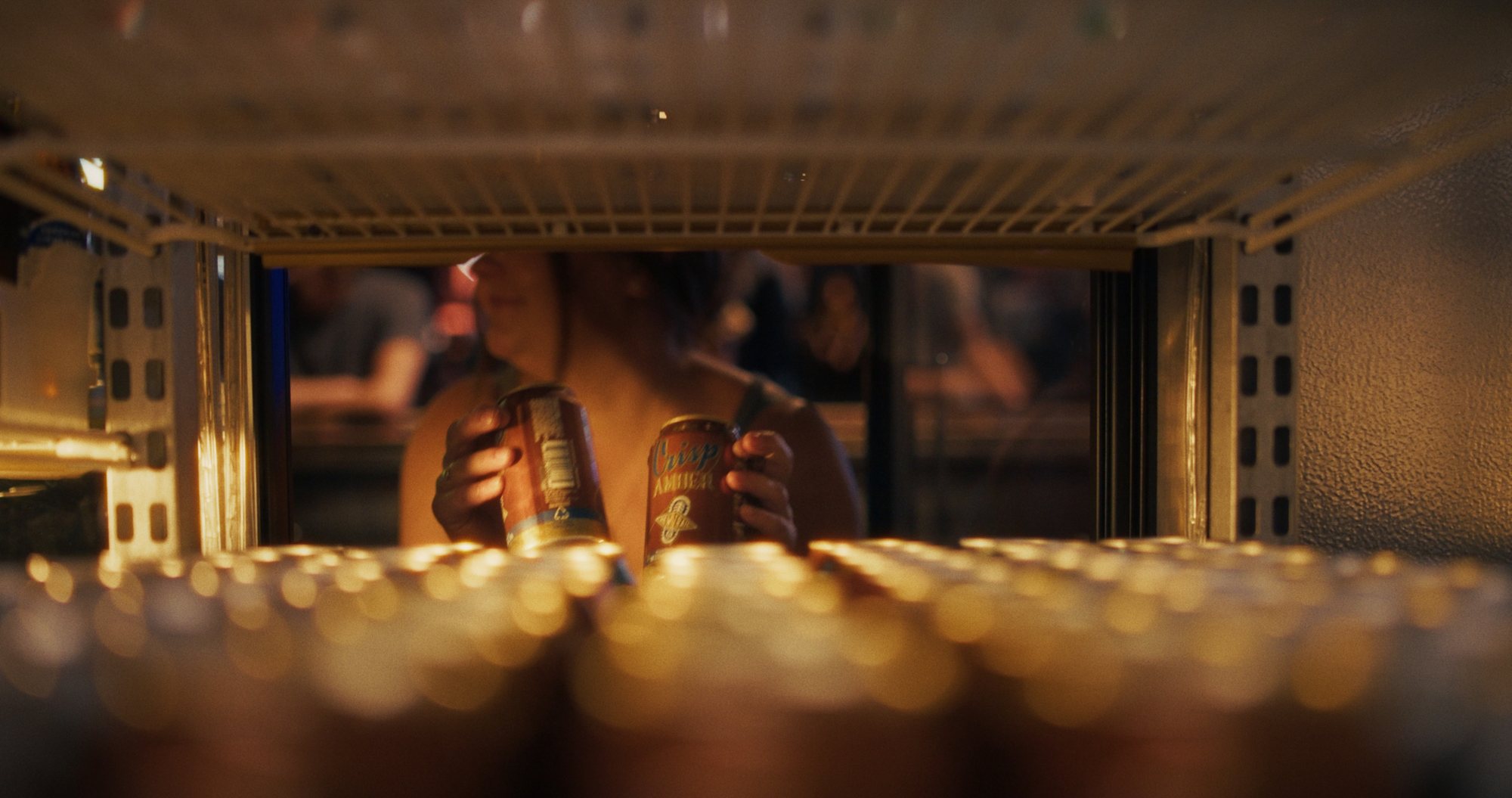 Crisp Amber cans pulled from a beer fridge, spot frame