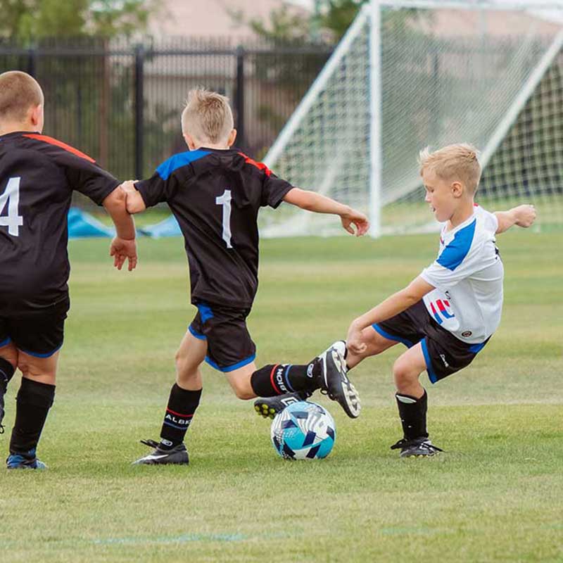 Children playing a soccer match on a sports field