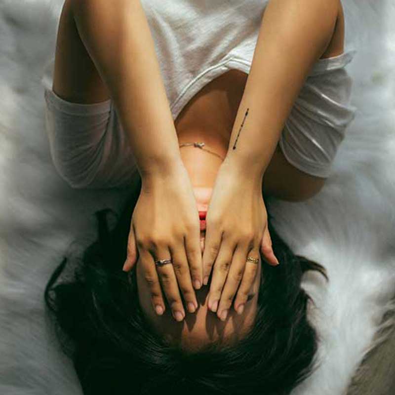 Woman resting with her hands covering her face