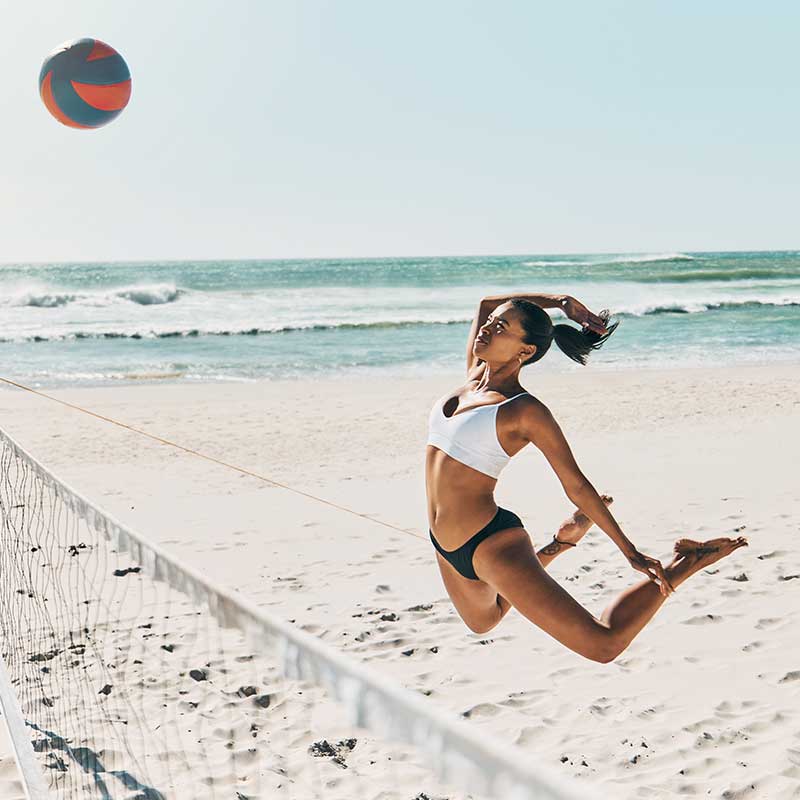 Woman spiking the ball during a beach volleyball game