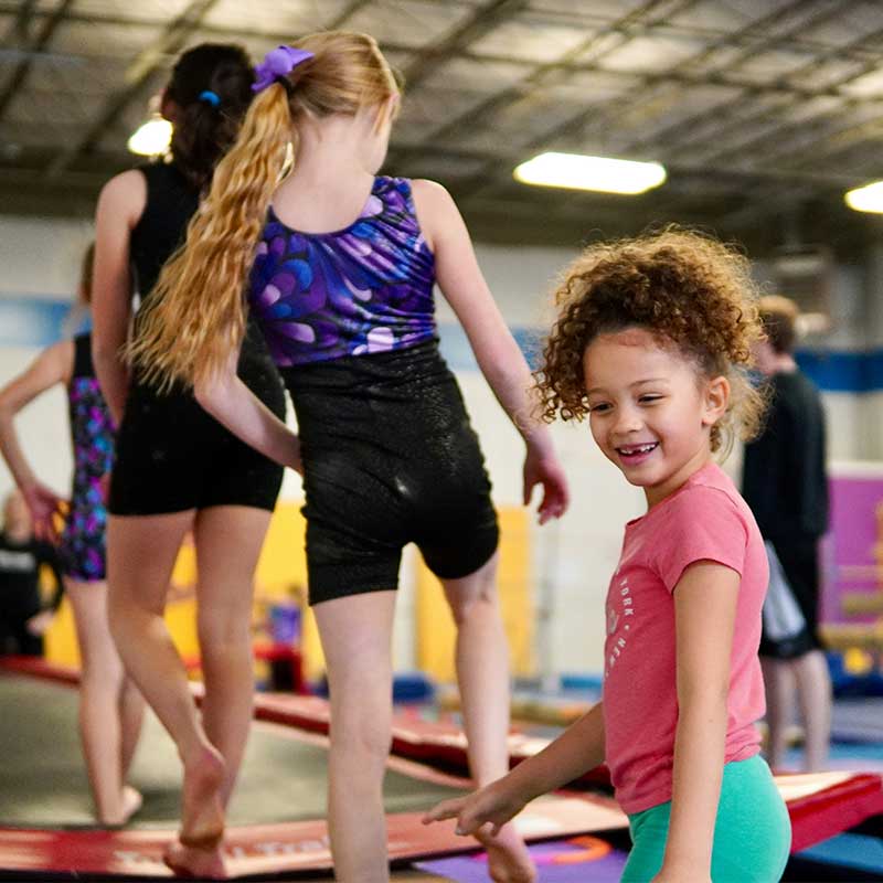 Young girls at gymnastics training, lining up for their turn on the trampoline