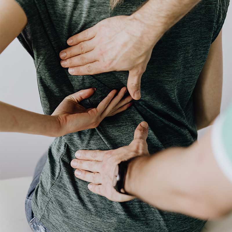 Woman patient showing physiotherapist where pain is in her back