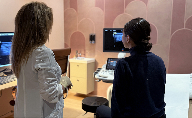 Médecin et patient consultant des images d’échographie sur des écrans médicaux dans une salle de consultation.