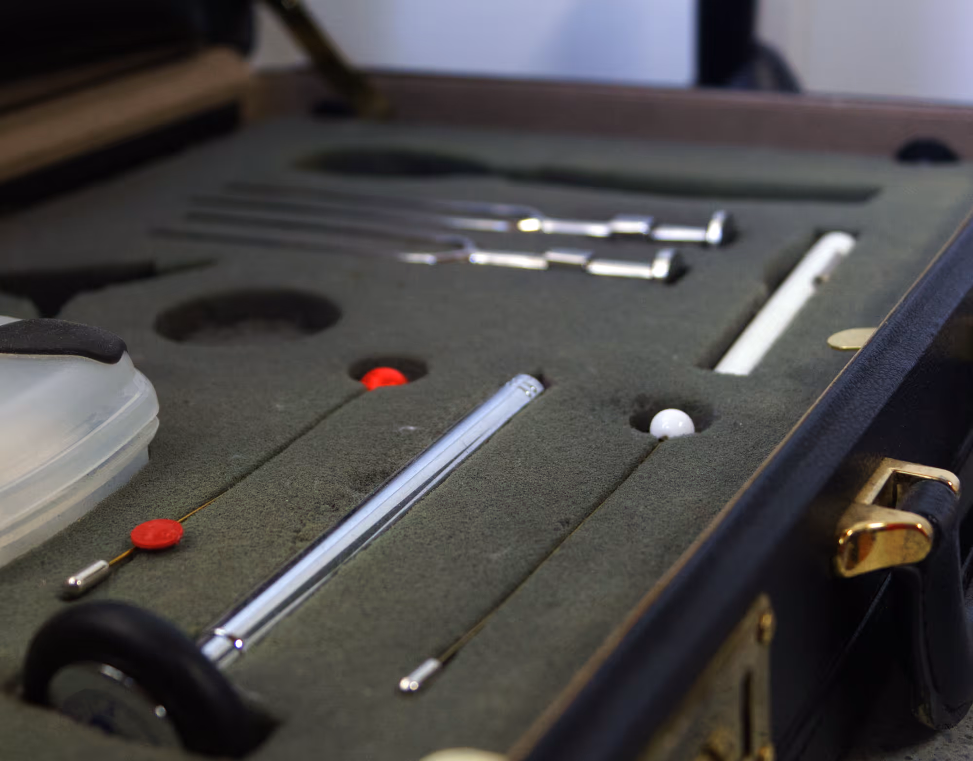 Open case with a grey foam insert holding various metal neurological examination tools and probes.