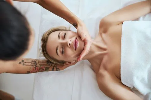 Eine Frau erhält eine entspannende Gesichtsmaske in einem Spa und genießt die wohltuende Massage.