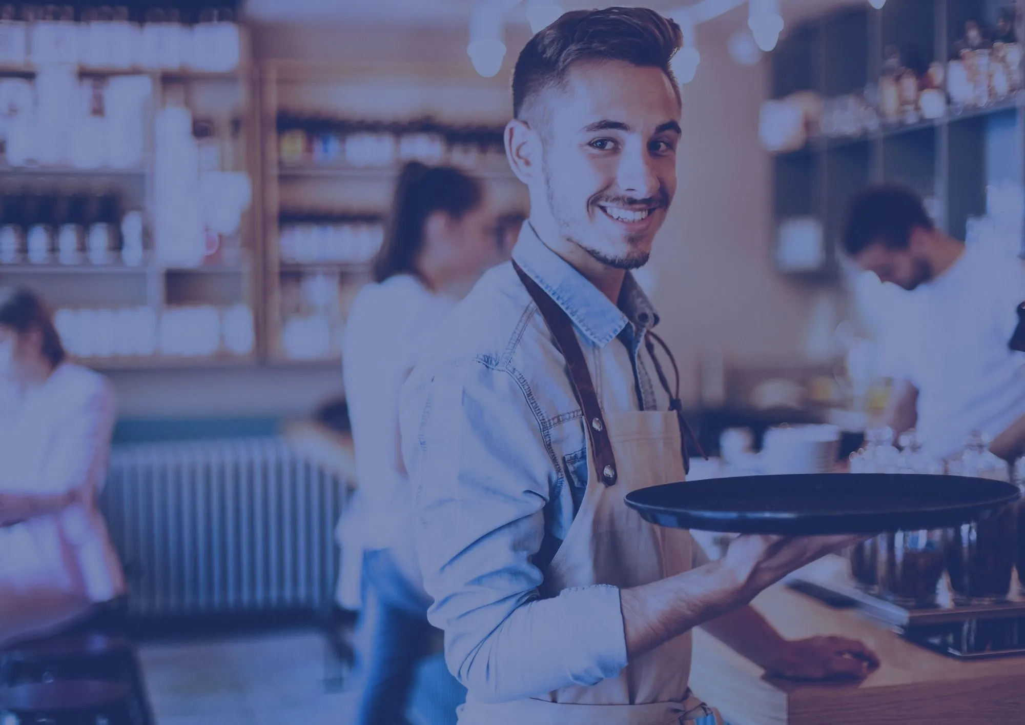 Serveur avec un plateau dans la main préparant une commande dans un café