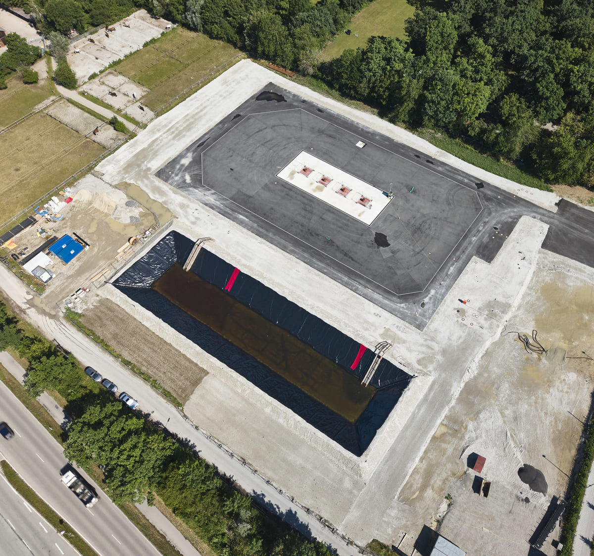 Luftaufnahme des vorbereiteten Geothermie-Bohrplatzes in Gräfelfing mit Testwasserbecken, Juli 2026.