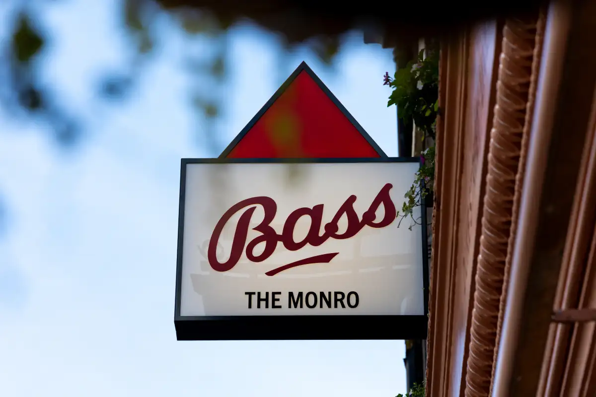 “Bass The Monro” sign hanging outside a building.
