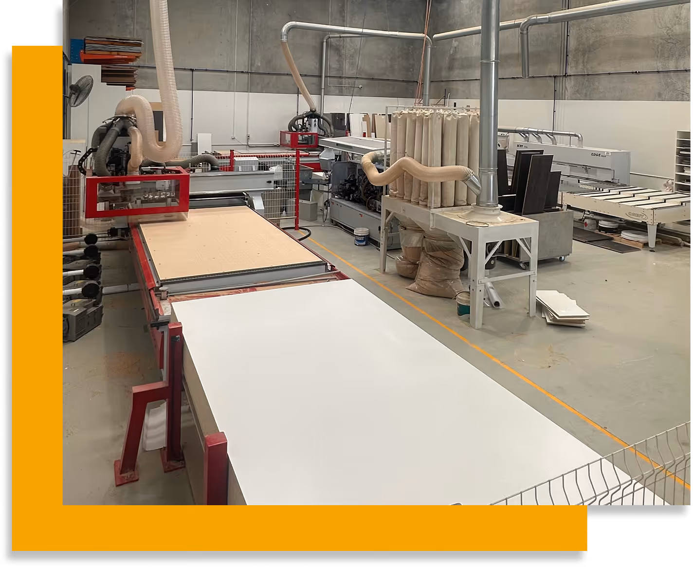 Large industrial woodworking machine with dust extraction tubes in a clean factory setting.