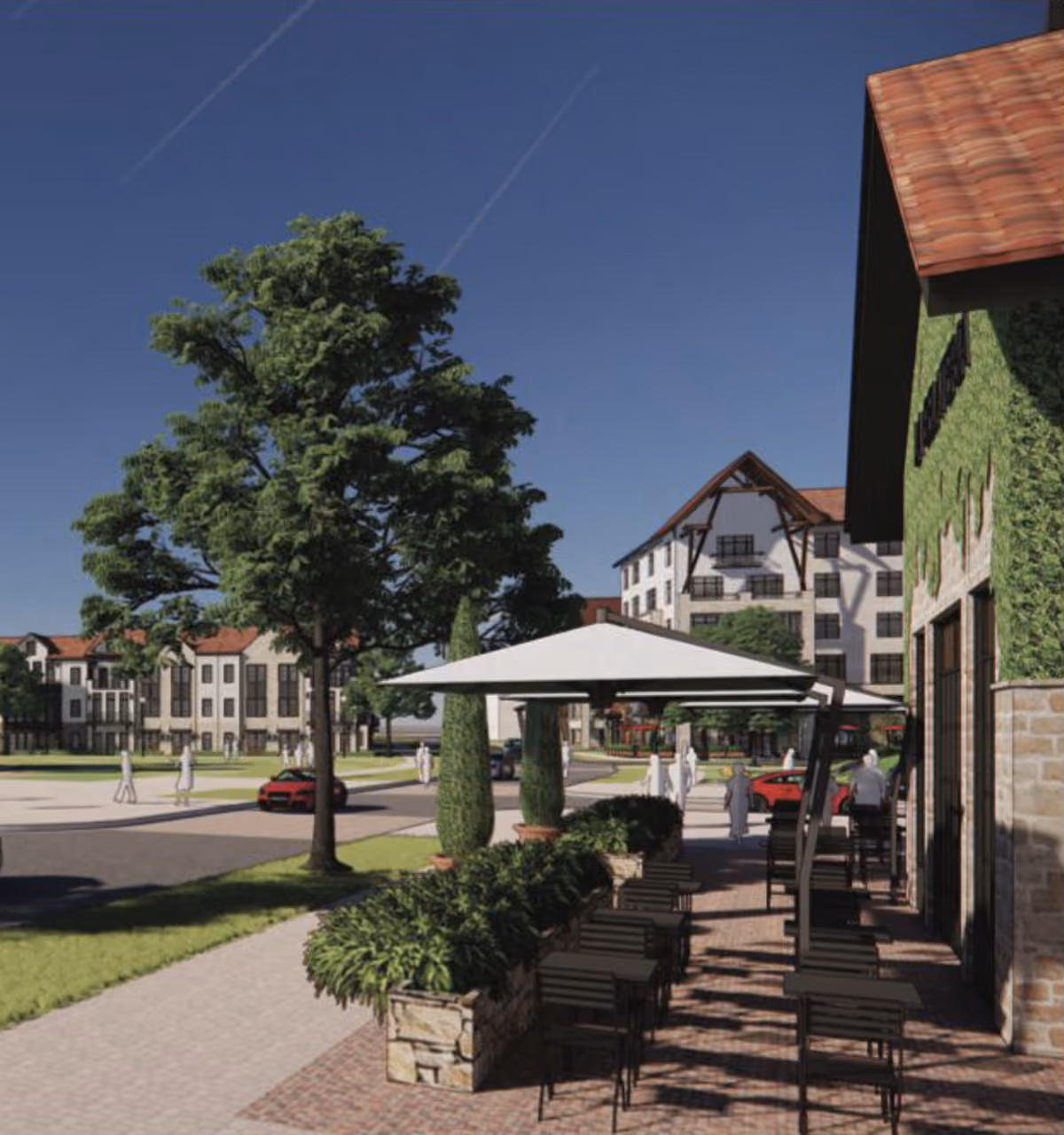 Outdoor seating area with black chairs and white umbrellas near residential buildings and trees under blue sky.