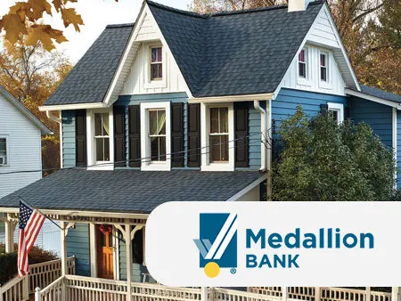 Two-story house with blue siding and gray roof, featuring Medallion Bank logo