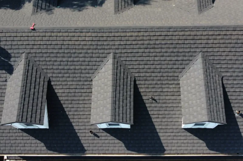 Aerial view of a stone-coated metal roof with three dormer windows