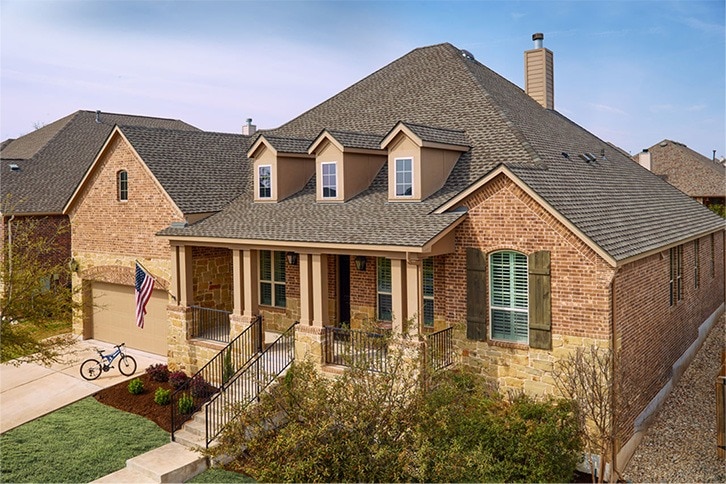Brick home with a new architectural shingle roof and dormers