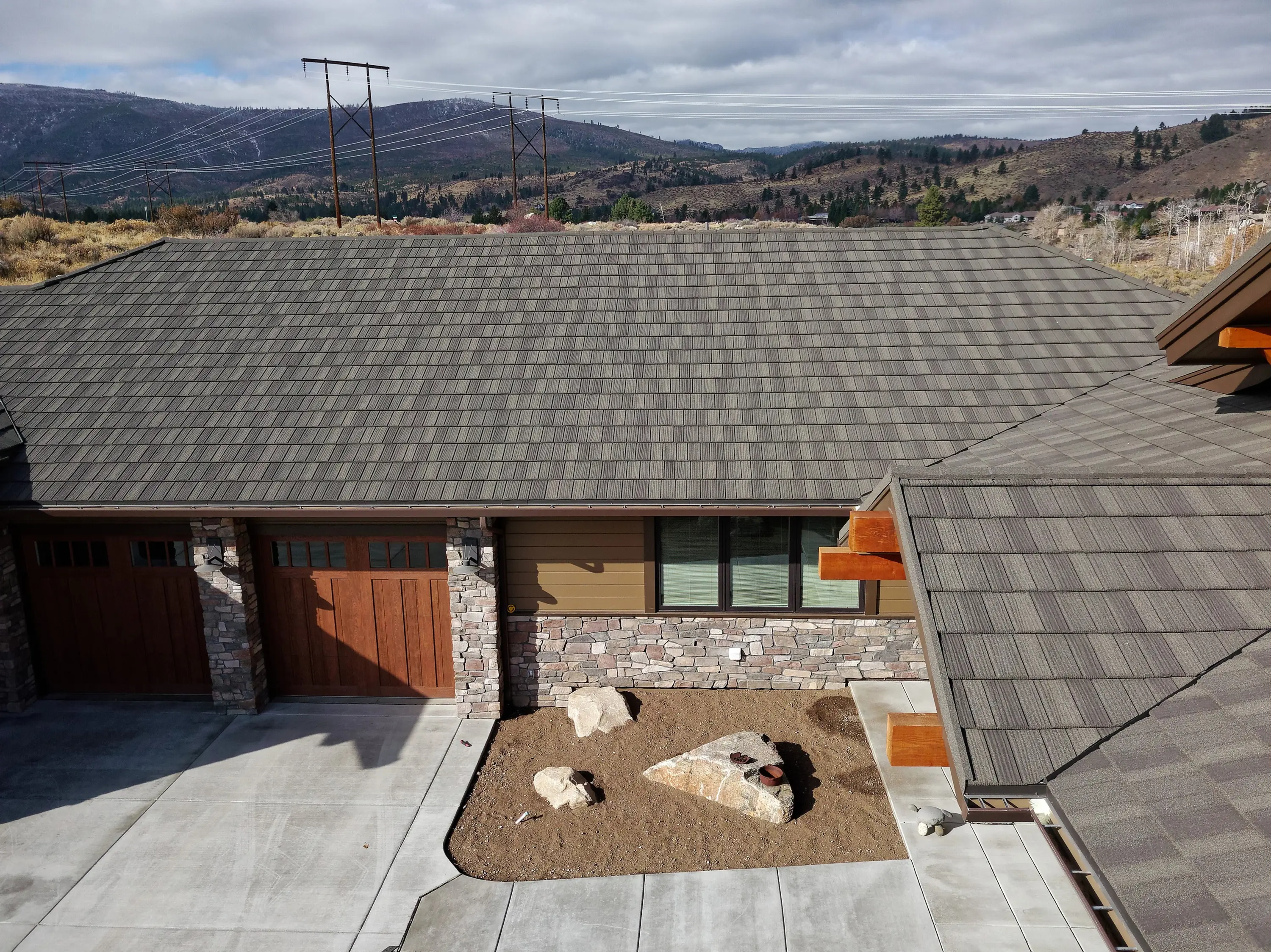 Close view of a gray stone-coated metal roof over a two-car garage