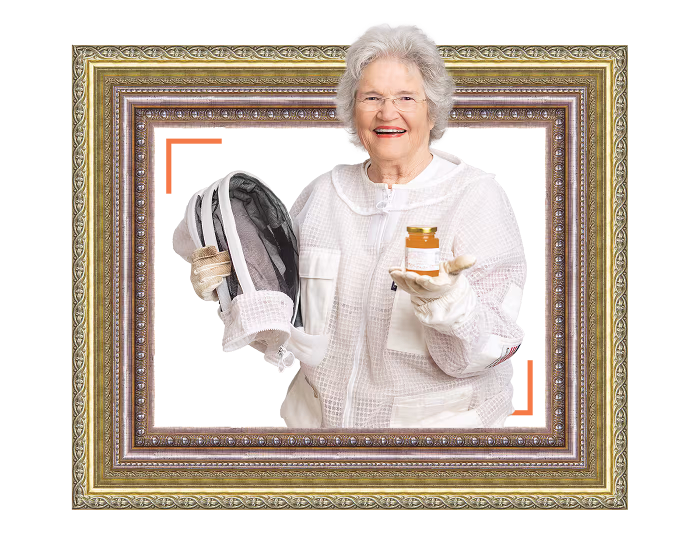 Elderly woman in beekeeper suit holding a beekeeping hat and a jar of honey, smiling.