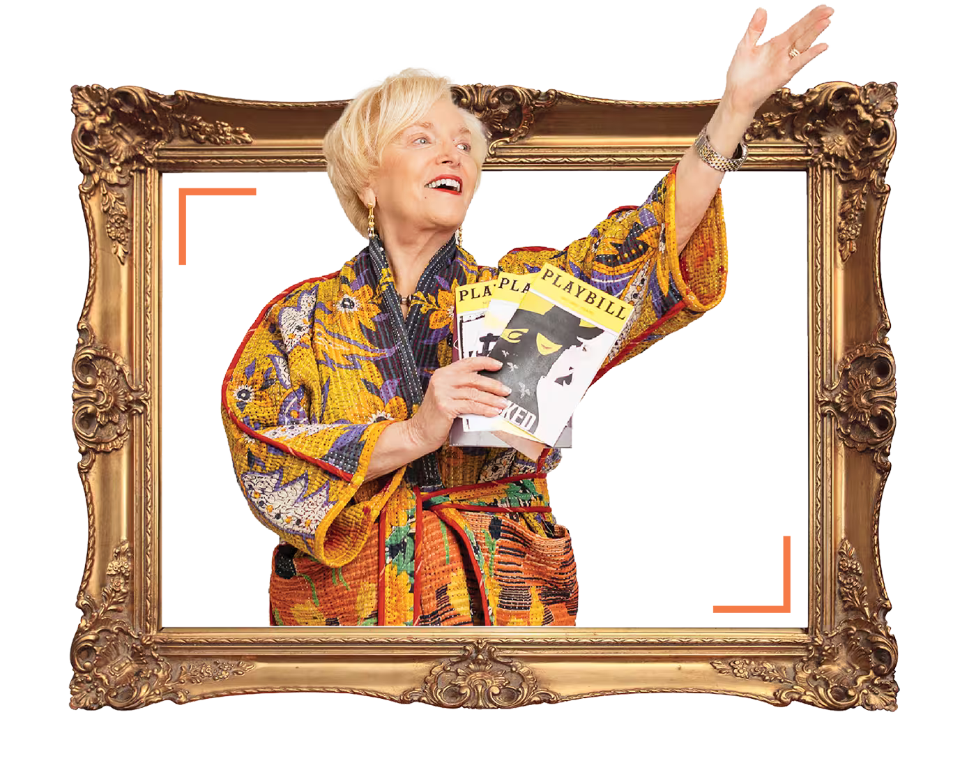 A person in a colorful robe holding playbills, posing in an ornate picture frame.