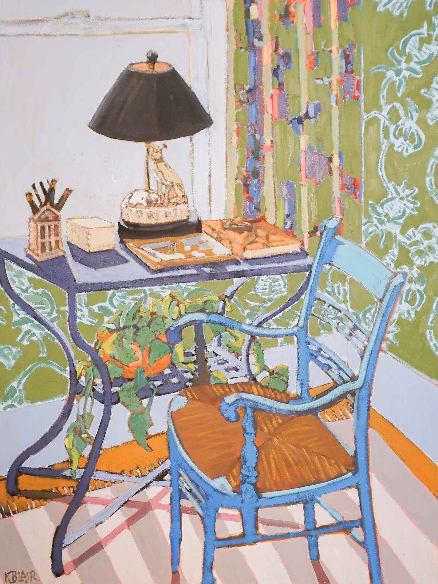 A colorful room with a small blue table, chair, and lamp beside a patterned wall.