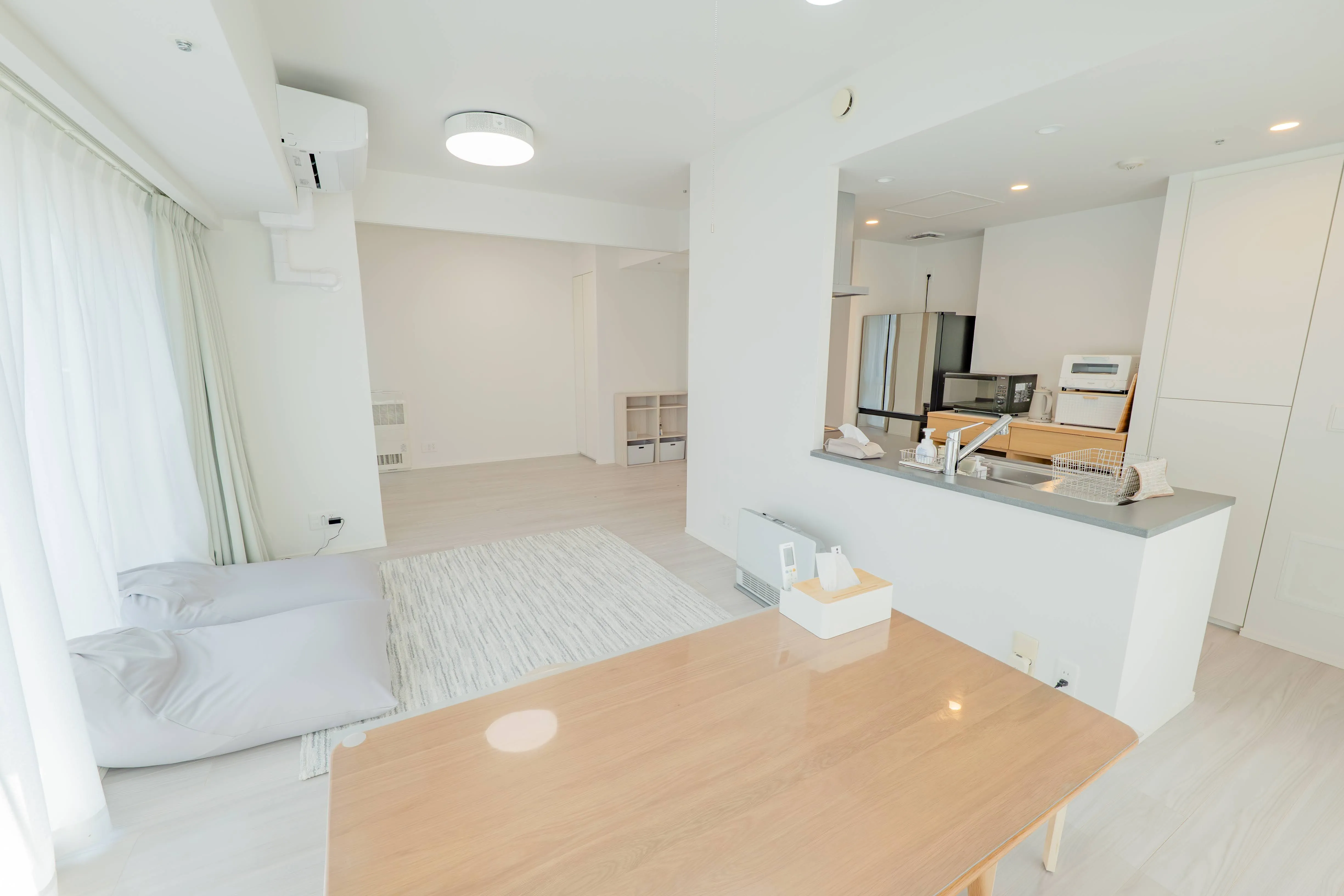 Living room and kitchen of Room 911 at ONE Sapporo Station Tower.