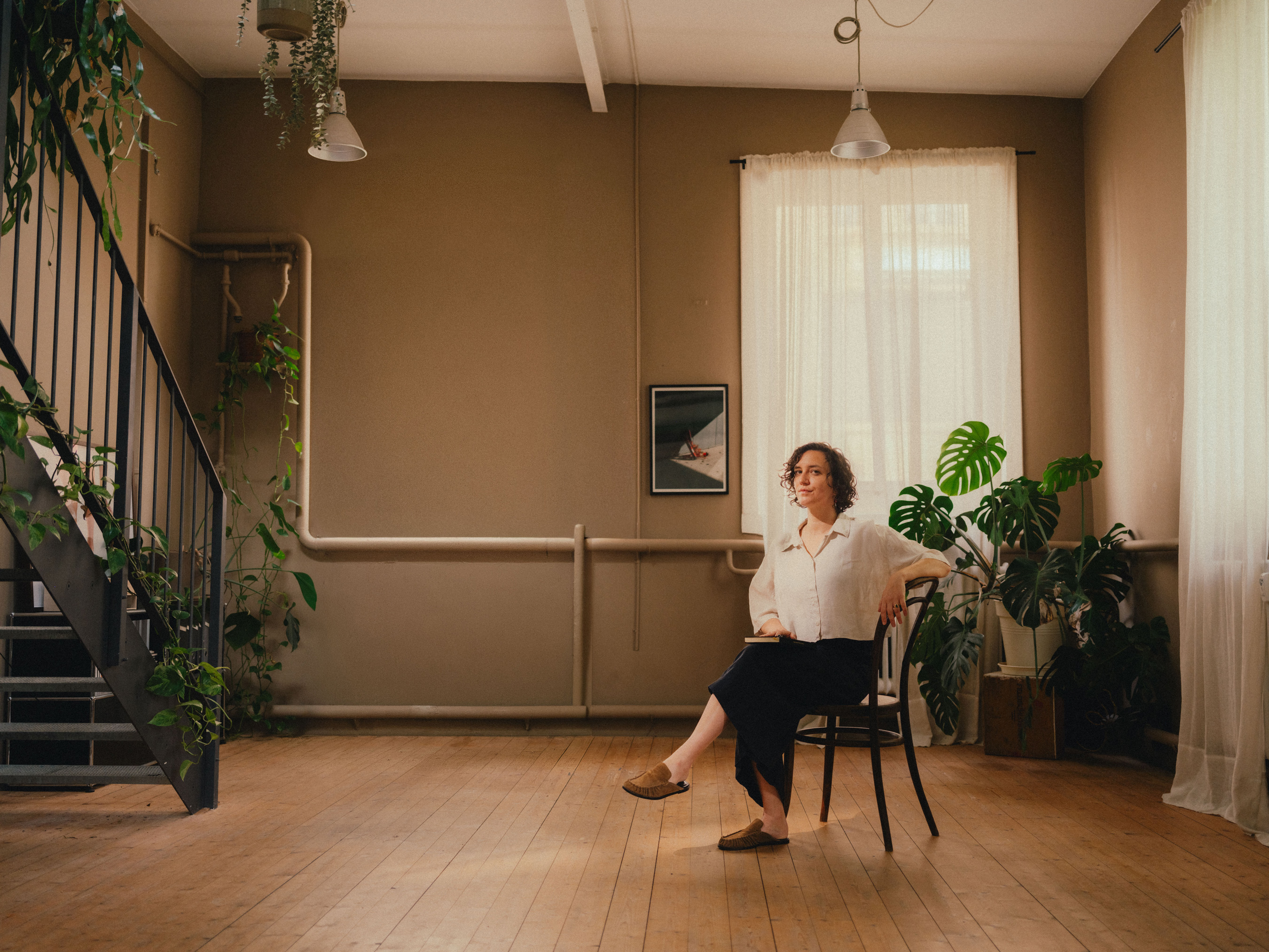 Laura Boss sitzt mit Notizbuch in einer ruhigen, professionellen Coaching-Atmosphäre und wirkt aufmerksam und zugewandt.