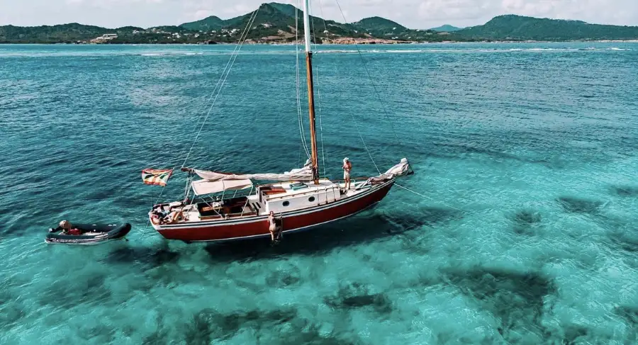 Savvy traditional wooden sloop in clear Caribbean water
