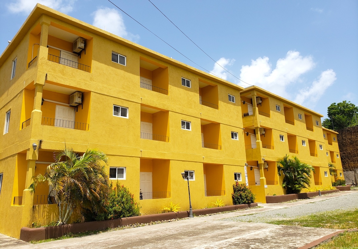 Carenage Suites — yellow building in True Blue
