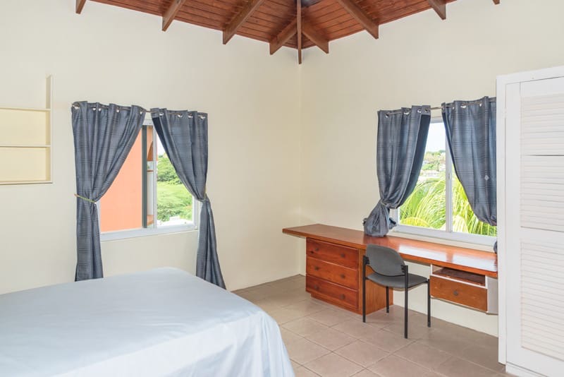 Representative furnished bedroom with timber ceiling and study desk in Mateo's apartment complex