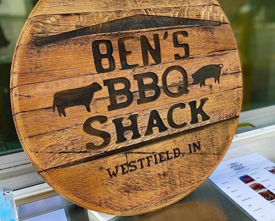 A wooden sign with the words Ben's BBQ Shack on it.