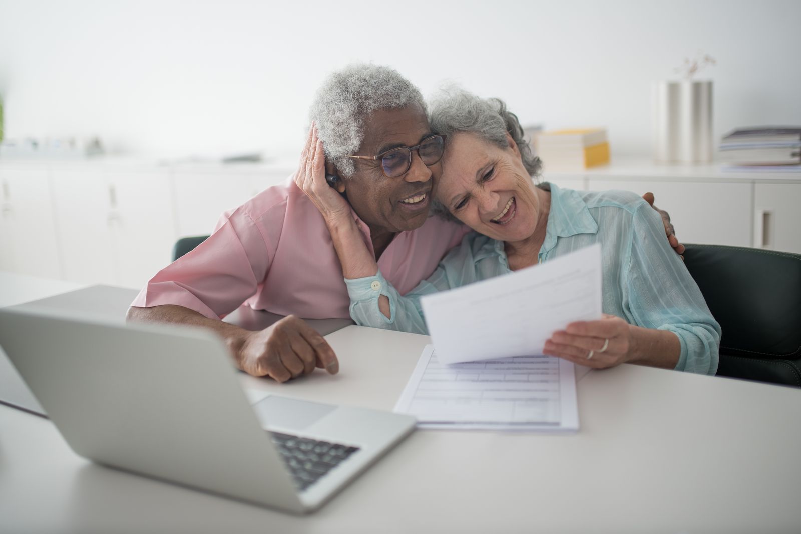 A smiling older couple reviewing a financial plan together at home