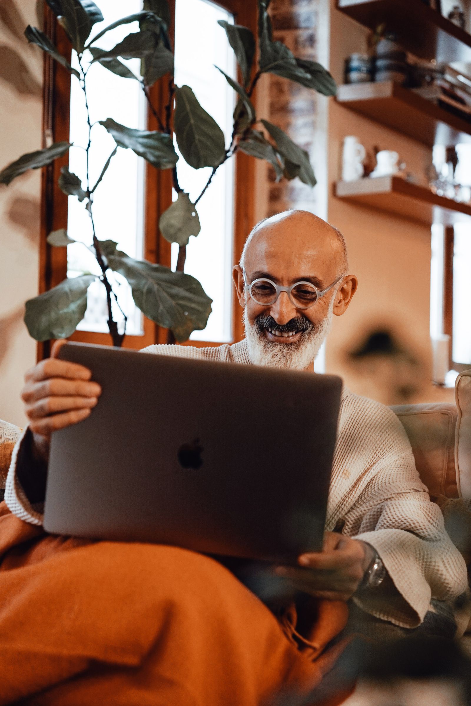 A relaxed retiree reviewing finances on a laptop at home