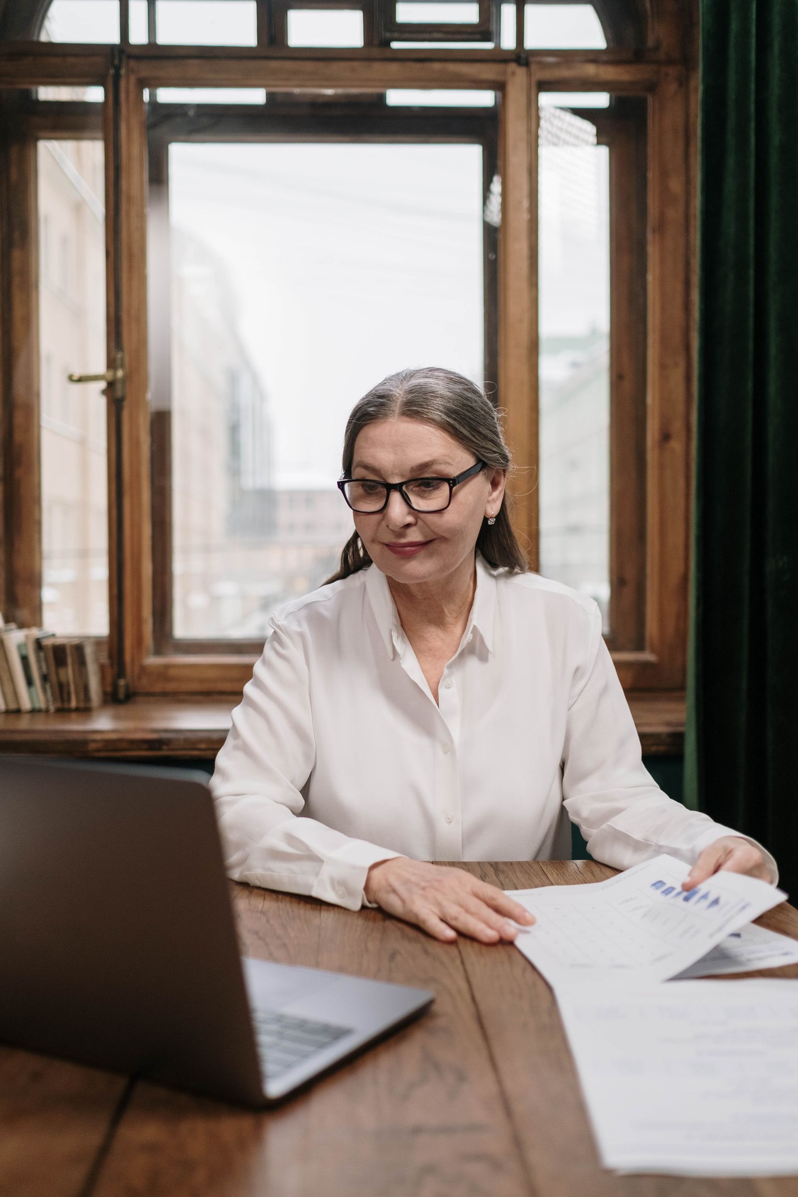 A woman reviewing retirement paperwork at her desk