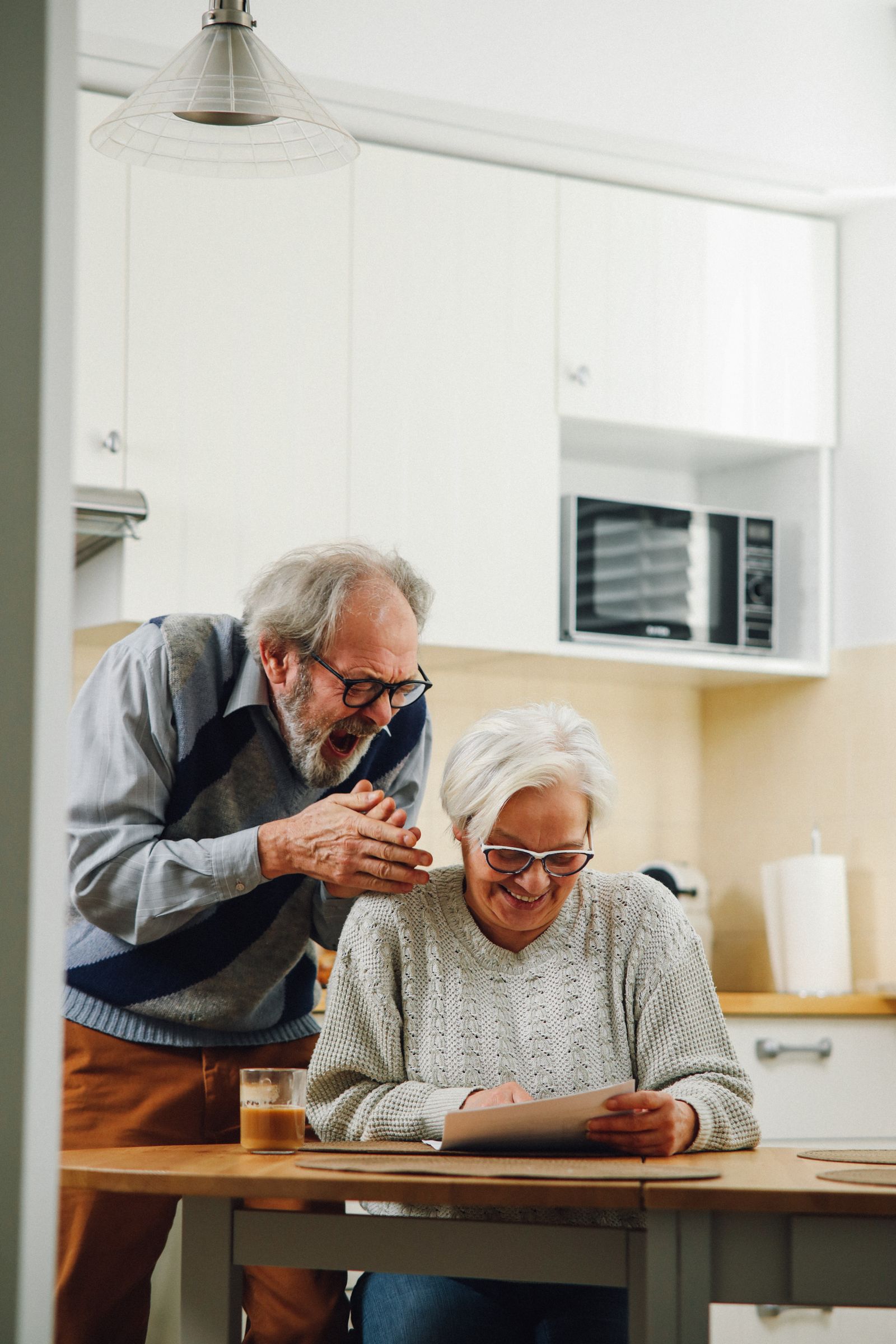 An older couple reviewing information together in their kitchen