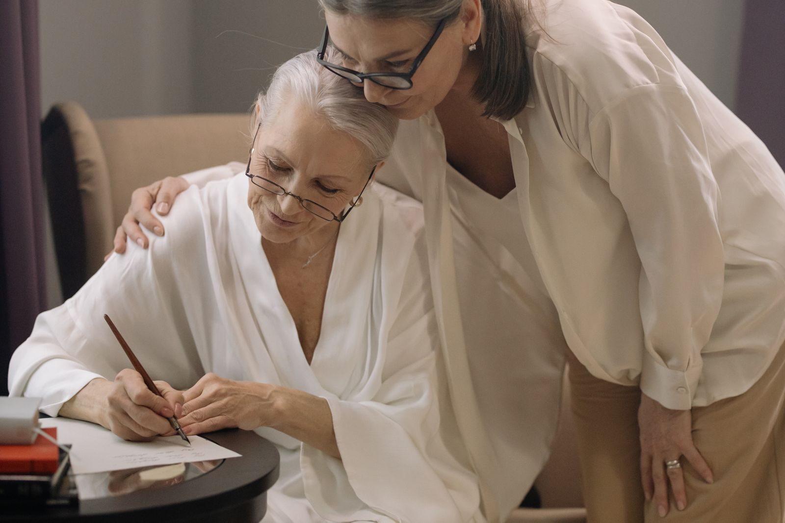 An adult daughter helping her mother with paperwork at home