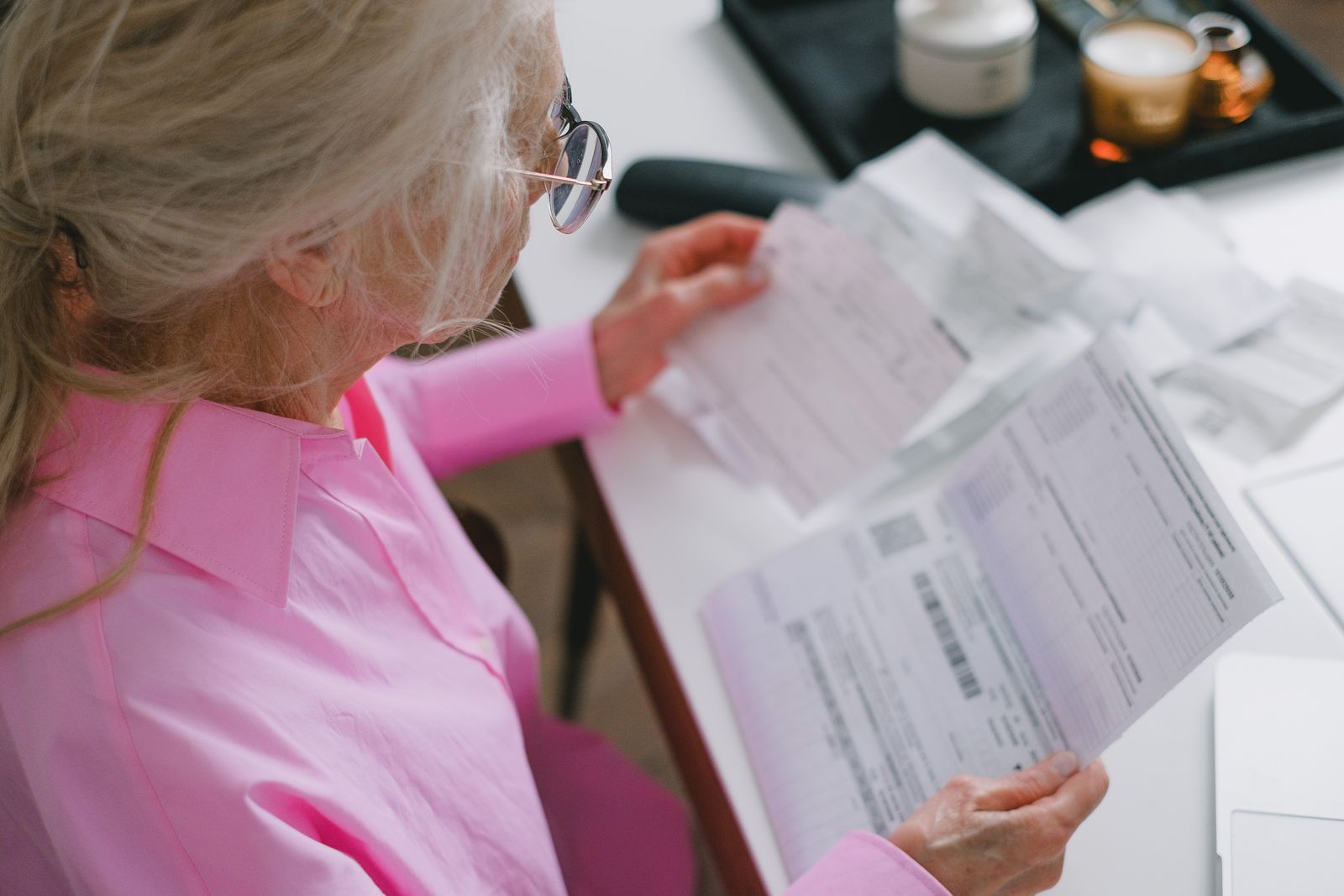 An older adult carefully reviewing Medicare statements at home