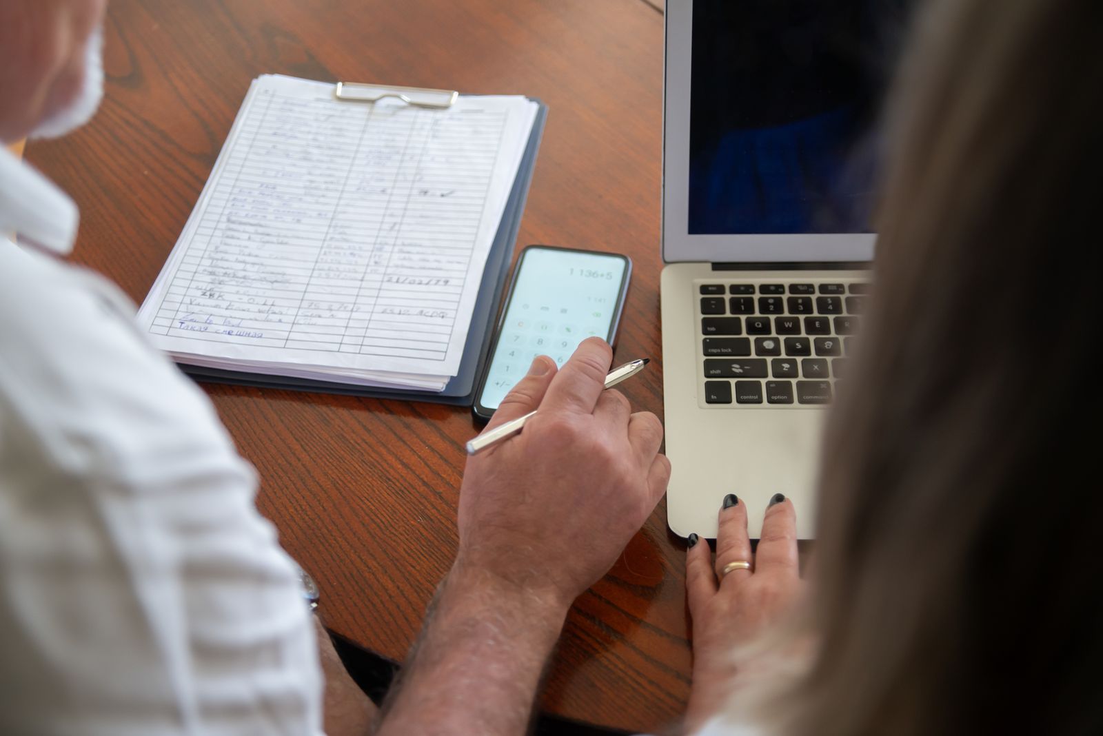 Hands filling out a simple retirement planning worksheet at a kitchen table