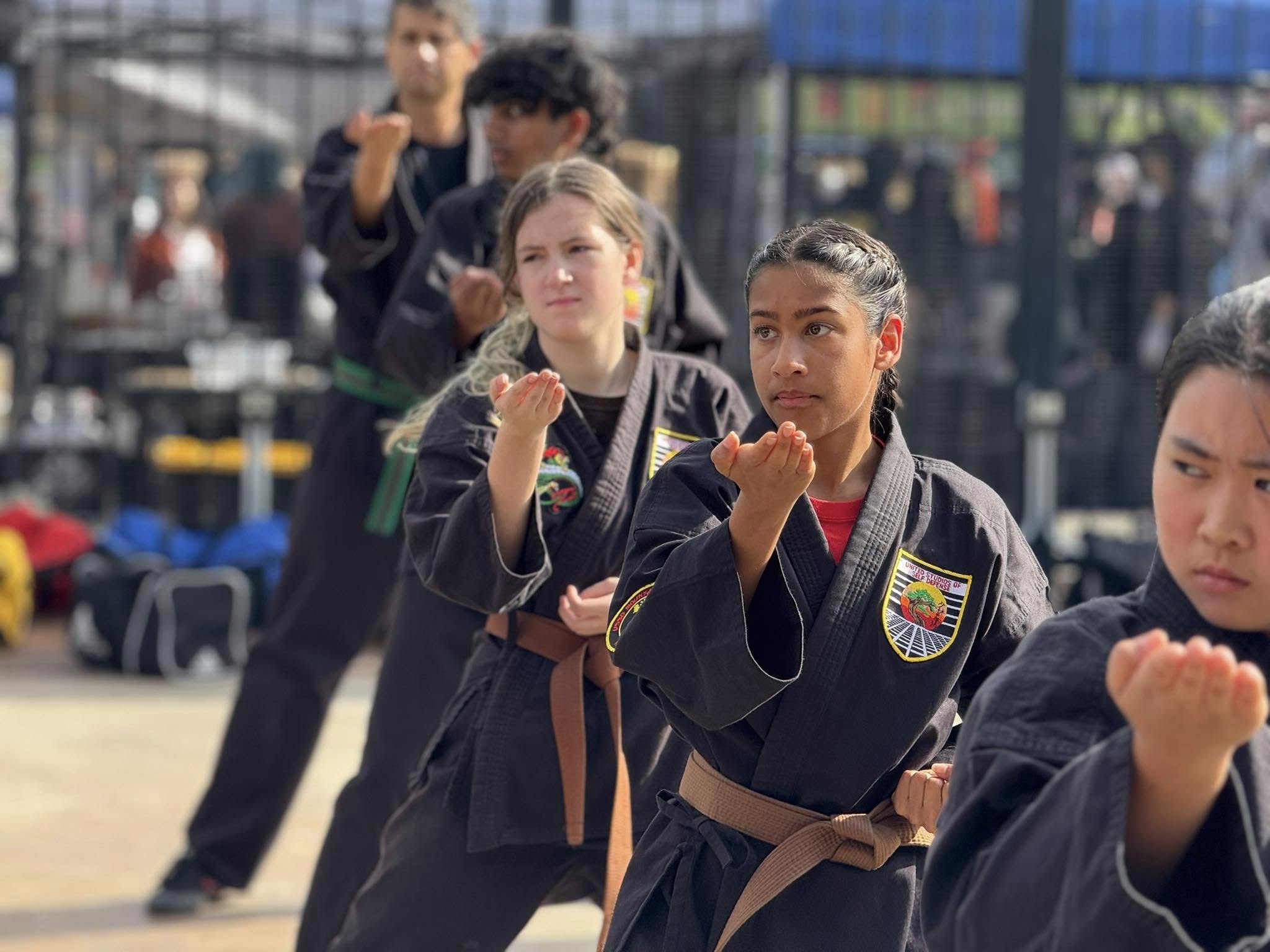 Karate instructor adjusting a student's punch 