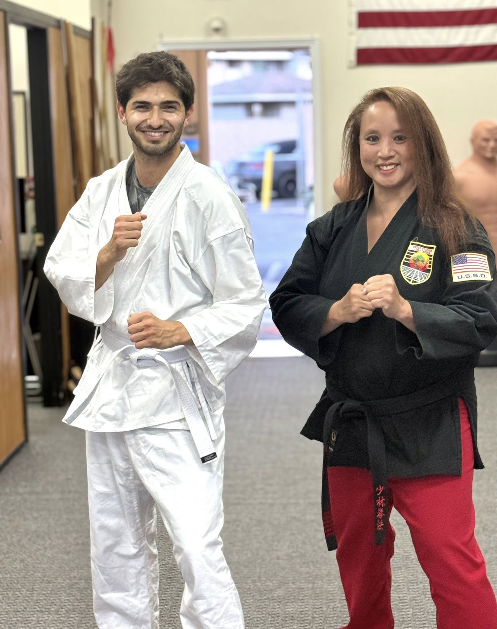 Adults Smile as they hold their karate tournament awards.