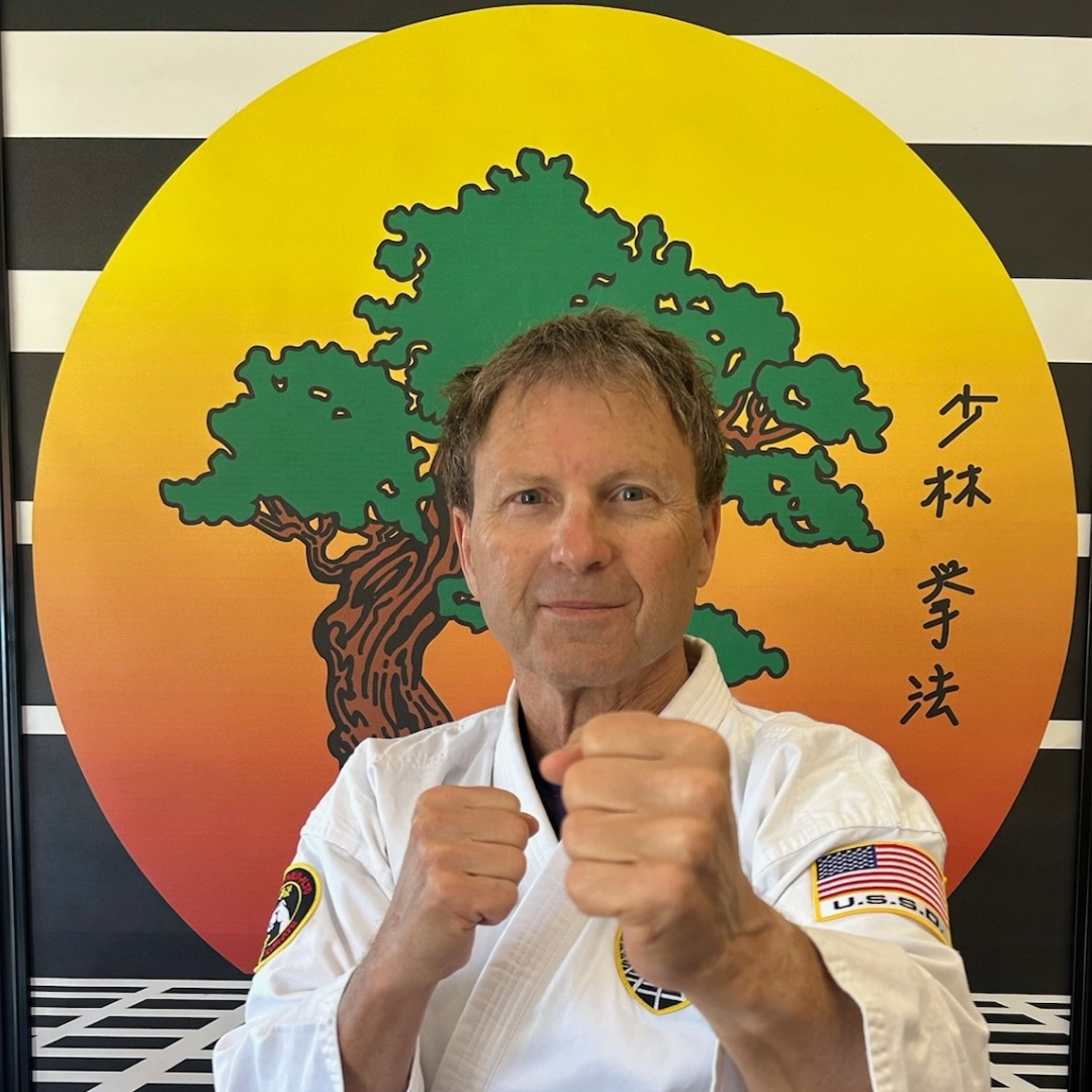 Adults Smile as they hold their karate tournament awards.