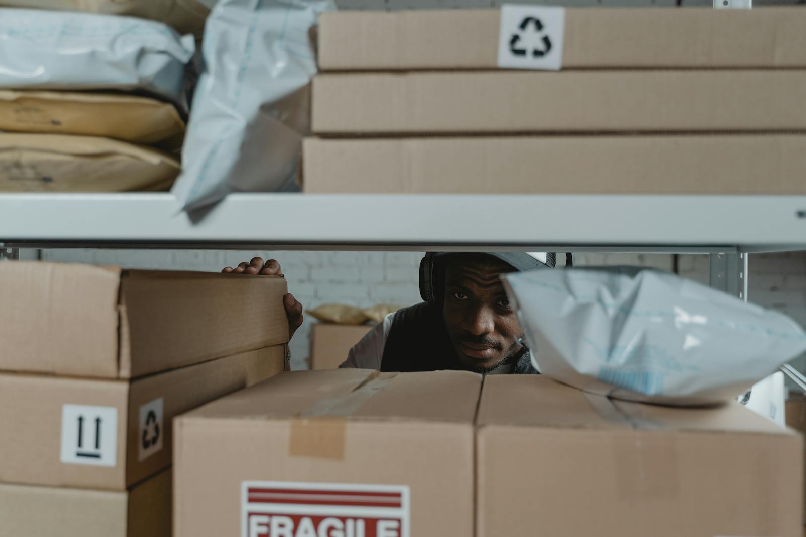 Warehouse worker inspecting shipment packages on shelves