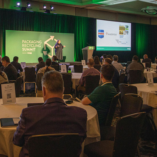 Audience sitting in chairs looking at speaker and presentation at Packaging Recycling Summit event