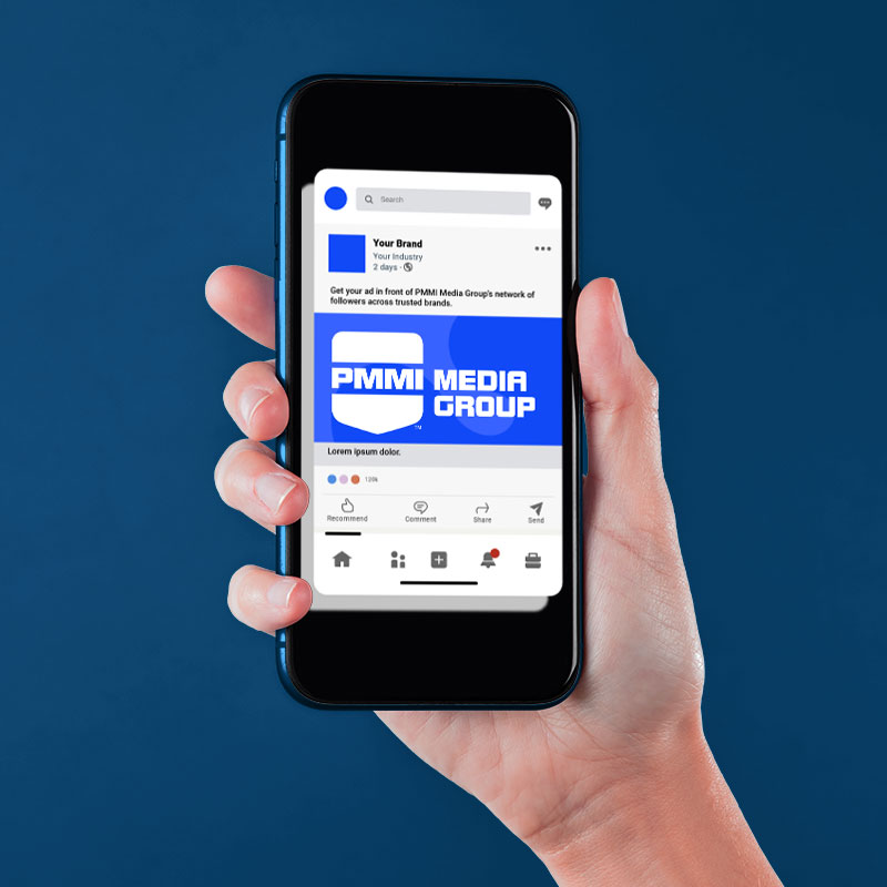 Hand holding a phone showing social media from PMMI Media Group