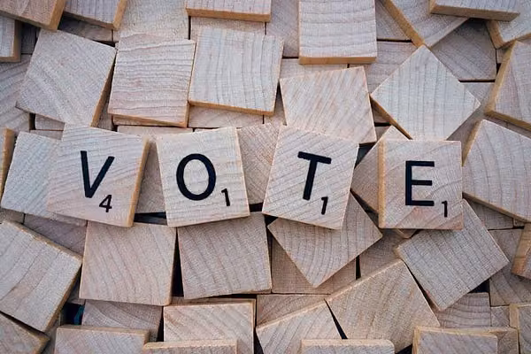 排列成 VOTE 字樣的木製字母磚,散放在其他空白木磚上