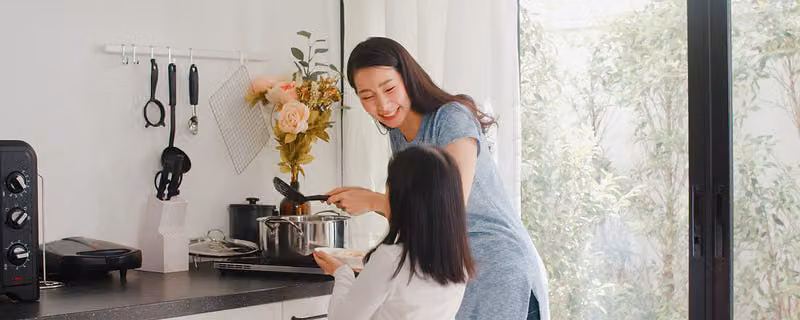 女兒跟母親相互對望,在廚房互動聊天