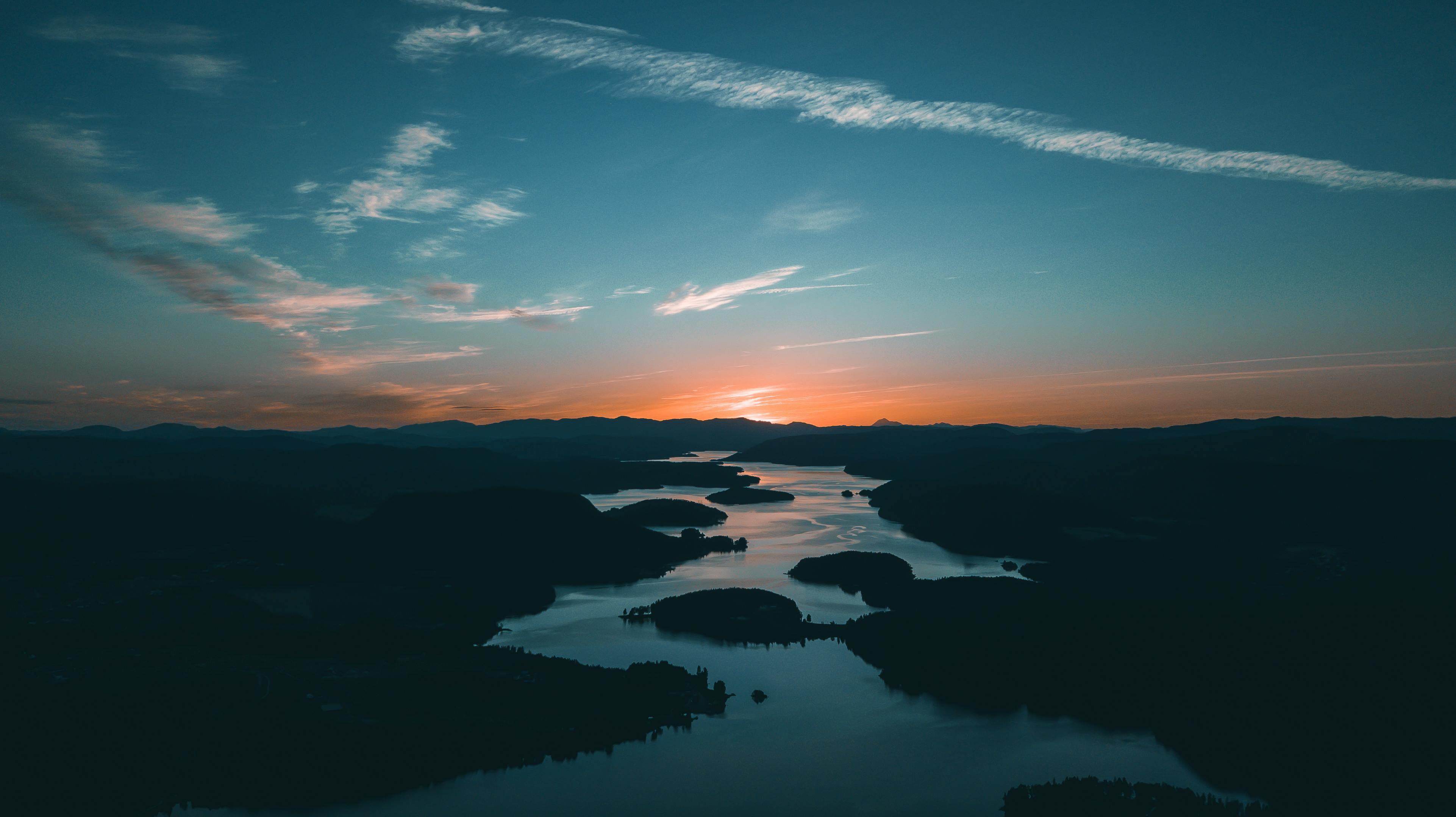Aerial view of a winding river through lush green landscape at golden hour