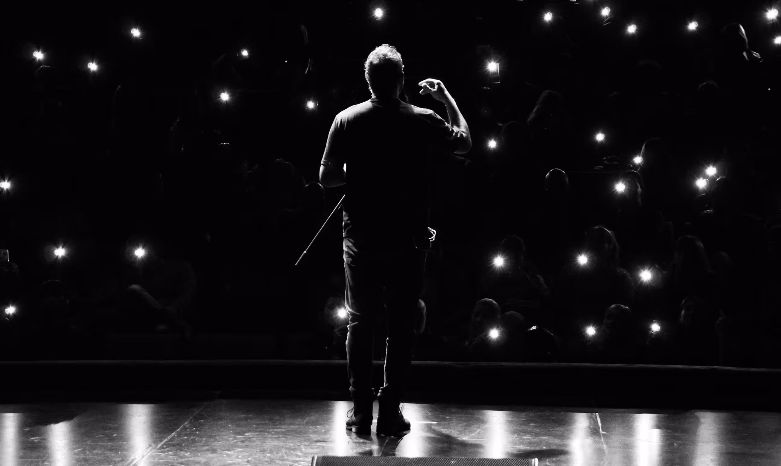 speaker on stage in front of phone lights