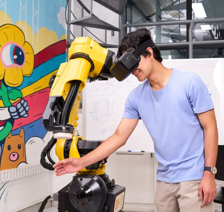 Estudiante usando gafas de realidad virtual con brazo robótico